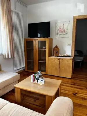a living room with a coffee table and a tv at Appartamento Le Sipole in Ziano di Fiemme