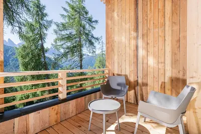 two chairs and a table on a balcony with a view at Munt Dolomiti Farm in Plancios