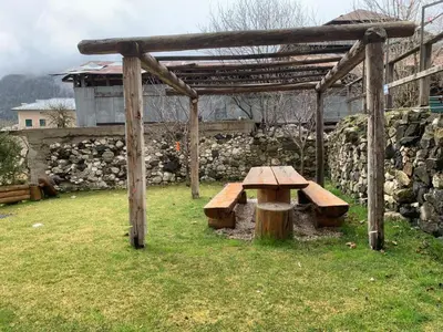 a wooden picnic table sitting under a wooden pergola at Chalet le Dolomiti in Borca di Cadore