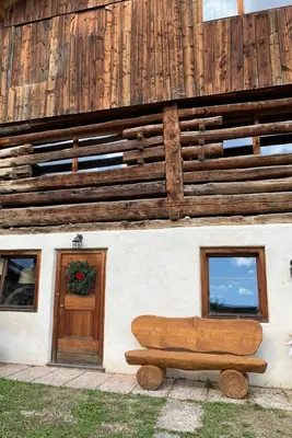 a wooden bench sitting in front of a building at Chalet le Dolomiti in Borca di Cadore