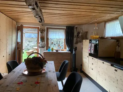a kitchen with a wooden table with a basket on it at Chalet le Dolomiti in Borca di Cadore