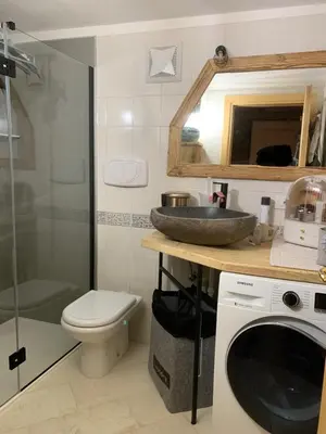 a bathroom with a sink and a washing machine at Chalet le Dolomiti in Borca di Cadore