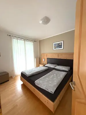 a bedroom with a large bed with a wooden headboard at Apartment Apfel in Naturno
