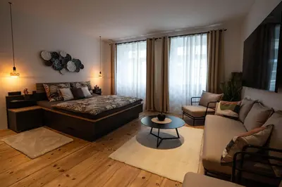 a bedroom with a bed and a living room at Laubennest 1 in Merano