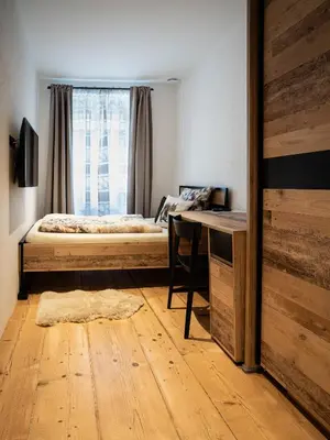 a bedroom with a bed and a desk and a window at Laubennest 1 in Merano