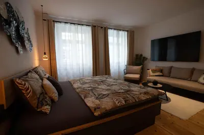 a bedroom with a bed and a living room at Laubennest 1 in Merano