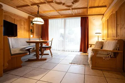 a living room with a table and a television at Traditional Cozy Apartment in Tirolo