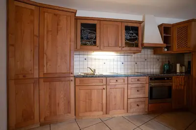 a kitchen with wooden cabinets and a sink at Traditional Cozy Apartment in Tirolo