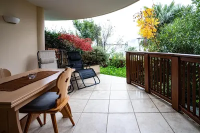 a patio with a wooden table and chairs on a deck at Traditional Cozy Apartment in Tirolo