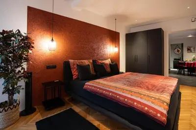 a bedroom with a bed and a table in a room at Laubennest 2 in Merano