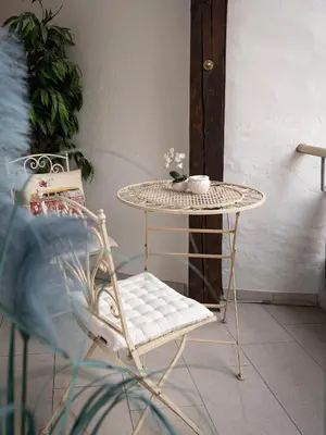 a rattan table and a chair with a table and a table at Laubennest 2 in Merano