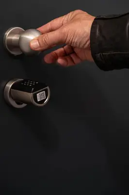 a hand holding a door handle with a remote control at Laubennest 2 in Merano