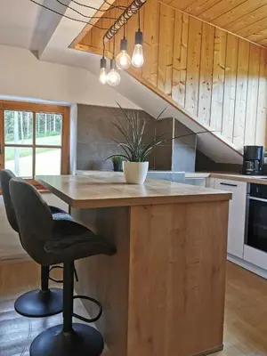 a kitchen with a wooden island with a table and a chair at Haus Maria in Campolasta