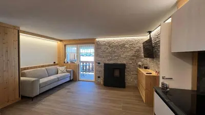 a living room with a couch and a fireplace at Appartamento Pampeago n 1 in Stava