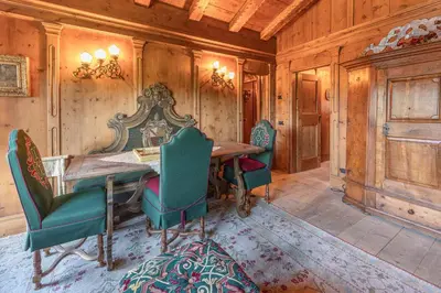 a dining room with a wooden table and chairs at Casa Cirmoli, confortevole mansarda con balcone panoramico in Cortina dʼAmpezzo