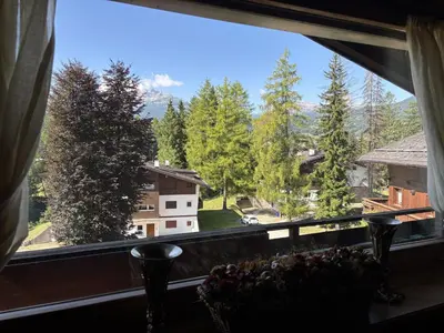 a window with a view of a mountain at Casa Cirmoli, confortevole mansarda con balcone panoramico in Cortina dʼAmpezzo
