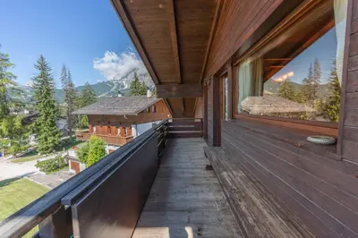 a balcony of a house with a view of the mountains at Casa Cirmoli, confortevole mansarda con balcone panoramico in Cortina dʼAmpezzo