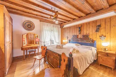 a bedroom with a bed and a desk and a table at Casa via dei Prati, ampia e confortevole in centro in Cortina dʼAmpezzo
