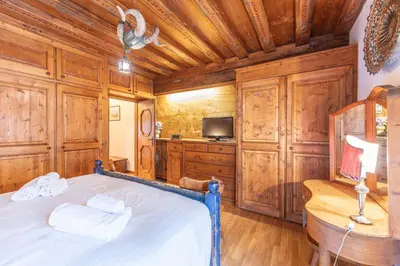a bedroom with a bed in a room with wooden cabinets at Casa via dei Prati, ampia e confortevole in centro in Cortina dʼAmpezzo