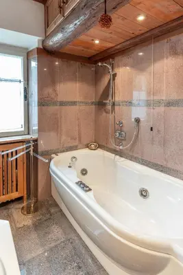 a white bath tub in a bathroom with a window at Casa via dei Prati, ampia e confortevole in centro in Cortina dʼAmpezzo
