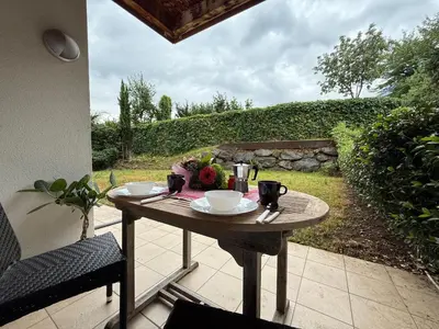 a wooden table with plates and cups on a patio at MarlingoStar con giardino e garage in Marlengo