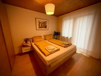 a bedroom with a bed with yellow sheets and a window at MarlingoStar con giardino e garage in Marlengo