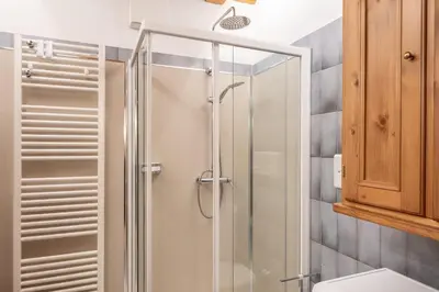 a shower with a glass door in a bathroom at Beautiful ground floor flat few steps from centre in Cortina dʼAmpezzo