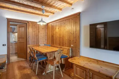 a dining room with a wooden table and chairs at Beautiful ground floor flat few steps from centre in Cortina dʼAmpezzo