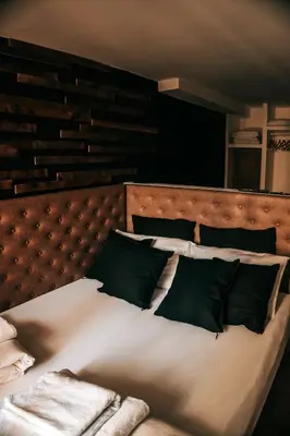 a bed with white sheets and green pillows at Sir Thomas Bed Central in Bolzano