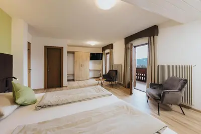 a bedroom with a bed and two chairs in a room at Hotel Restaurant Alber in Verano