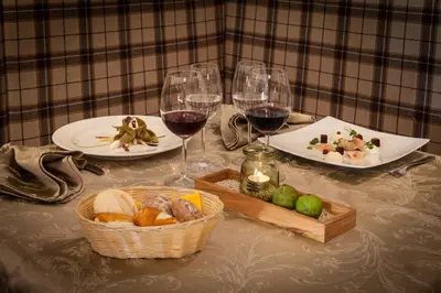a table with two glasses of wine and a basket of food at Hotel Restaurant Alber in Verano