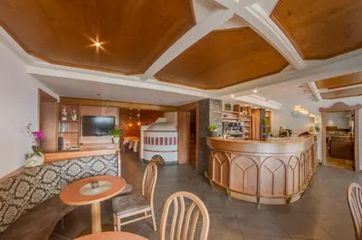 a living room with a bar and a kitchen at Hotel Restaurant Alber in Verano