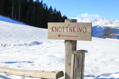 a wooden sign that reads knotalling on a snow covered slope at Hotel Restaurant Alber in Verano