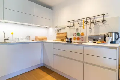 a white kitchen with white cabinets and appliances at Proventus Apartments in Perca