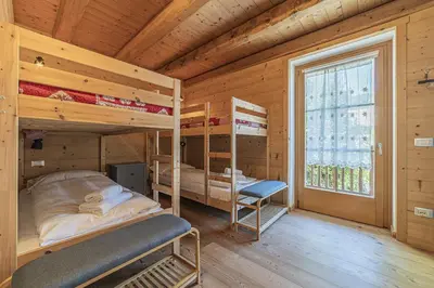 a bedroom with two bunk beds and a window at Alpine Heart in Falcade