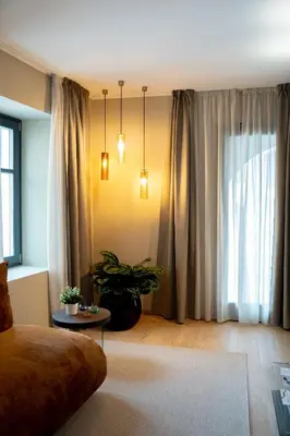 a living room with a couch and a large window at KODERLE SUITE K1 Bucaneve in Brunico
