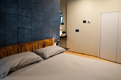 a bed in a room with a wall at Koderle Suite K2 Arnica in Brunico