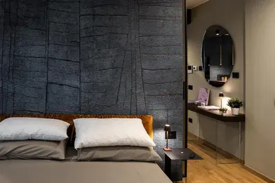 a bedroom with a bed and a black wall at Koderle Suite K2 Arnica in Brunico
