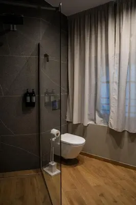a bathroom with a toilet and a glass shower at Koderle Suite K2 Arnica in Brunico