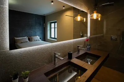 a bathroom with a sink and a bed in the mirror at KODERLE SUITE K4 Zampa D Orso in Brunico