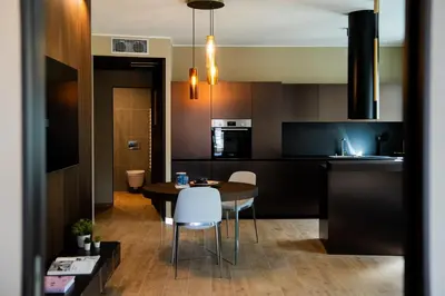 a kitchen and dining room with a table and chairs at KODERLE SUITE K3 Genziana in Brunico