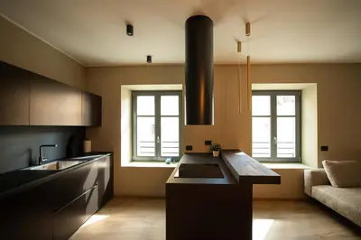 a kitchen with a island in the middle of a room at KODERLE SUITE K3 Genziana in Brunico