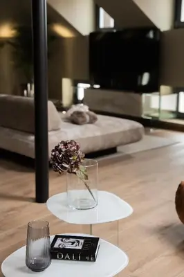 a vase with flowers on a table in a room at KODERLE SUITE K5 Stella Alpina in Brunico