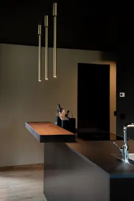 a kitchen with a counter with a sink and chandelier at KODERLE SUITE K5 Stella Alpina in Brunico