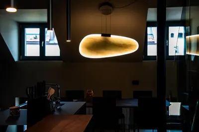 a dining room with a table and a light fixture at KODERLE SUITE K5 Stella Alpina in Brunico