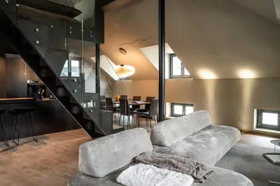 a living room with a couch and a staircase at KODERLE SUITE K5 Stella Alpina in Brunico
