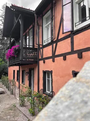 a building with a balcony with flowers on it at Studio Cervus with BrixenCard in Bressanone