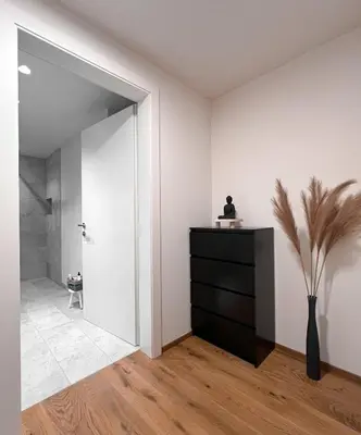 a room with a black dresser and a bathroom at Studio Cervus with BrixenCard in Bressanone