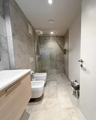 a bathroom with a toilet and a sink and a shower at Studio Cervus with BrixenCard in Bressanone