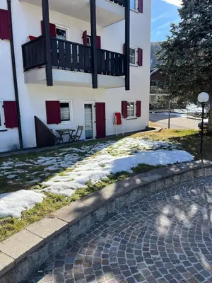 a building with a balcony and snow on the ground at Gianni's Home2 Santa Cristina VG in Santa Cristina in Val Gardena